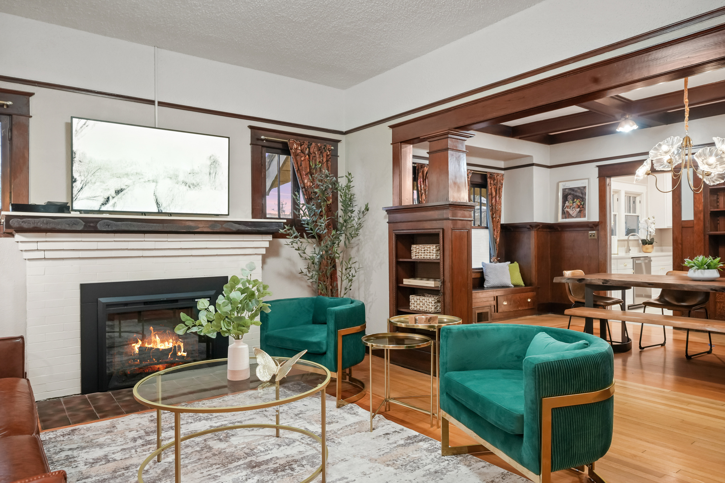 Vacation rental living room with a fireplace, teal chairs, and warm wood details